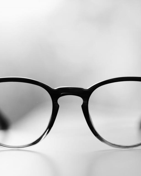 A pair of slim black spectacle frames on a plain white background